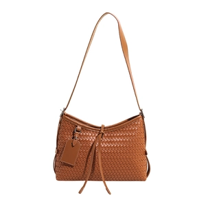Caramel brown woven leather shoulder bag with cross-stitch pattern and sleek tassel detail