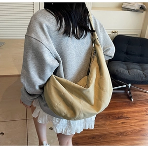 Detail of light yellow half-moon bag with decorative knot and premium stitching