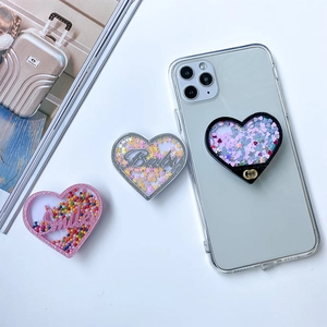 Detail von herzförmigen Handy-Halterungen mit flüssigem Treibsand und Glitzer-Pailletten