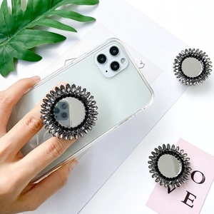 Luxury rhinestone mirror phone socket with collapsible grip on a white smartphone