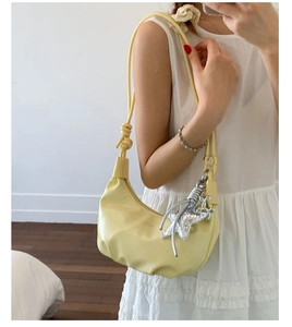Detail of light yellow leather hobo bag with star pendant and adjustable silver buckle