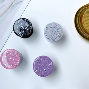 Macro view of glue-dipped phone socket stands with glitter stars and moon sequins