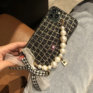 Glitter iPhone case featuring a pearl bracelet, houndstooth bow, and quilted pattern