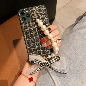 Luxe iPhone case with tweed texture, pearl hand strap, and large stylish bowknot detail