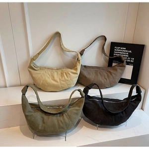 Modern quilted croissant shoulder bags in multiple colors displayed on marble steps