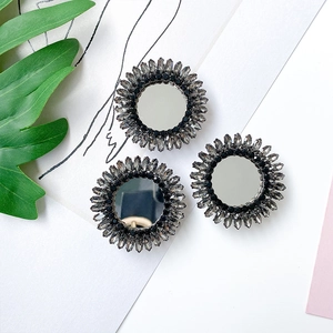 Close-up of rhinestone phone grips with mirror center and sunburst crystal design