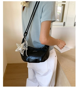 Detail of black leather hobo bag with star pendant and Fashion & Bag printed text