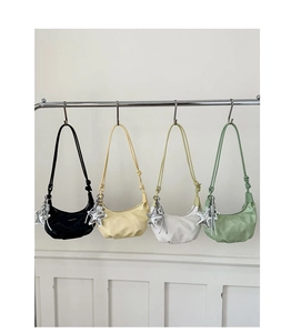 Detail of four colorful crescent shoulder bags with star charms hanging on a metal rack