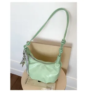 Detail of mint green half-moon bag with soft leather texture and star charm