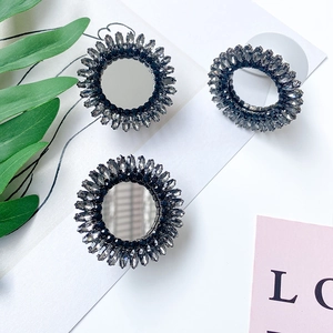 Flat lay of luxury rhinestone folding phone grips with mirror surface and dark crystals
