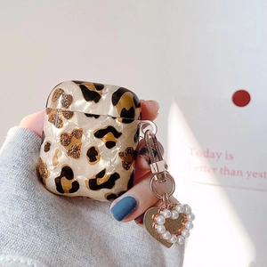 Coque AirPods à motif léopard et marbre avec pendentif cœur en perle tenue en main