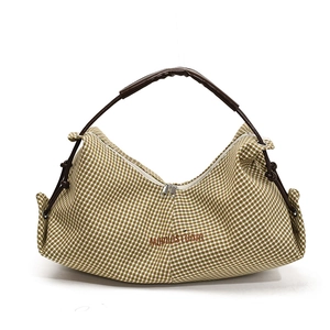 Green and white checkered shoulder bag with brown top handle and drawstring details