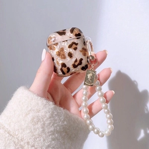 Coque AirPods léopard avec bracelet en perles et breloque médaille dorée élégante