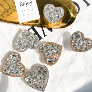 Macro shot of luxury heart-shaped crystal phone grip with sparkling rhinestone inlay