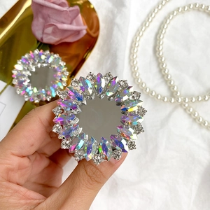 Macro detail of luxury rhinestone folding phone grip with iridescent gems and mirror surface