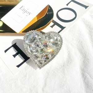 Detail view of a luxury heart-shaped phone grip with sparkling rhinestones and crystals