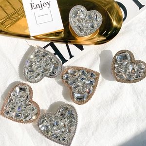 Macro detail of luxury heart-shaped phone stands with shimmering rhinestones and metal base