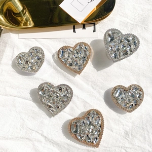Close-up of luxury heart-shaped phone grips with crystals in gold and silver colors