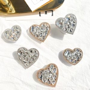 Detailed top view of luxurious heart-shaped rhinestone phone grips in silver and rose gold