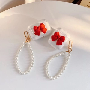 Clear AirPods case with red 3D velvet bow and white pearl carry handle strap