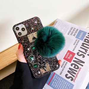 Luxury black glitter phone case with emerald gem chain and green faux fur pompom ball