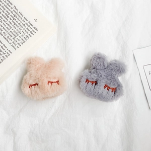 Close-up of soft plush rabbit phone grips with cute embroidered sleeping eyes detail