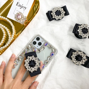 Detailed view of luxury rhinestone phone case with black ribbon bow expandable socket