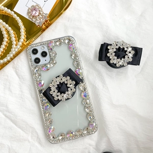 Close-up of luxury clear iPhone case with rhinestone edges and black bow grip