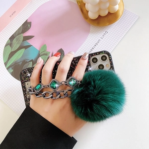 Black glitter phone case with green gem chain and fluffy faux fur pompom detail