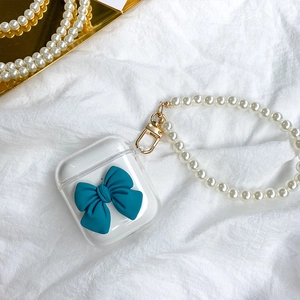 Clear TPU AirPods case featuring a teal 3D bow and elegant faux pearl wrist strap charm