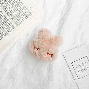 Detail of soft plush bunny accessory featuring delicate red embroidery and fluffy pink texture