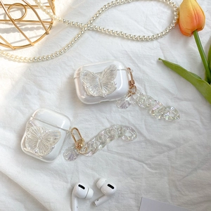 Detail of iridescent butterfly AirPods case with shell chain and elegant pearl decor