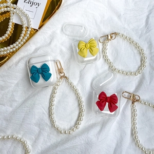 Detailed macro shot of clear AirPods case with colorful bow and pearl carry chain