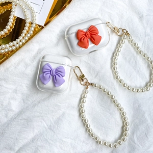 Detail of transparent AirPods case with 3D resin bow and pearl beaded lanyard strap