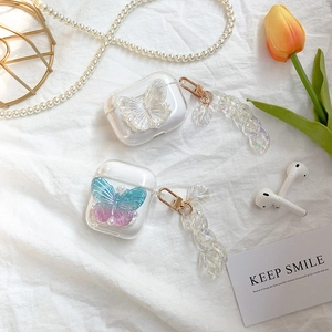 Transparent AirPods case with decorative 3D butterfly, pearl chain, and gold carabiner