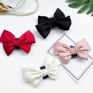 Detailansicht von vier Satin-Bogen-Handygriffen in Schwarz, Rot, Rosa und Weiß-Farben