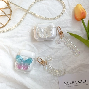 Close-up of clear AirPods case featuring 3D butterfly charms and colorful shell chain