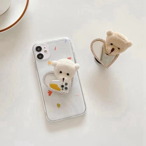 Detail of plush bear head and heart rhinestone socket on clear iPhone case