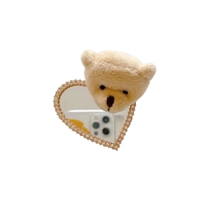 Detail of plush bear phone socket with heart-shaped rhinestone mirror and soft fur