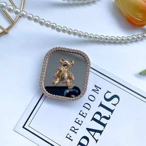 Macro detail of electroplated gold bear with rhinestones on mirror phone grip stand