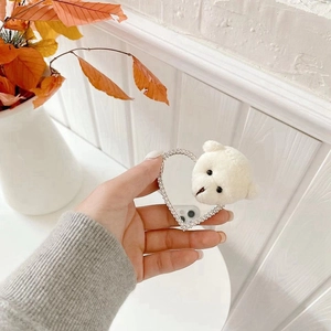 Detailed view of a heart-shaped phone grip with sparkling rhinestones and a plush bear