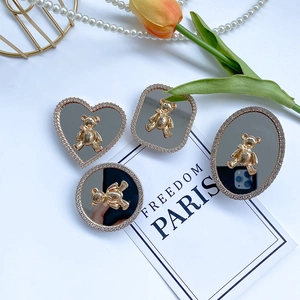 Flat lay of bear-motif mirror phone sockets with rhinestones and elegant French decor