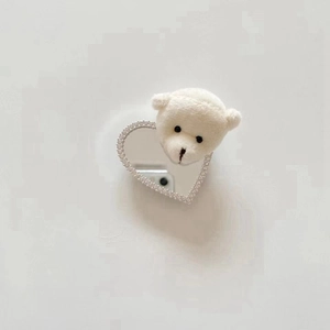 Close-up of plush white bear phone socket with heart mirror and sparkling rhinestones