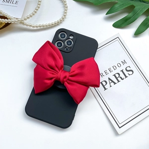 Schwarze matte Handyhülle mit großer roter 3D-Schleife auf minimalistischem Hintergrund
