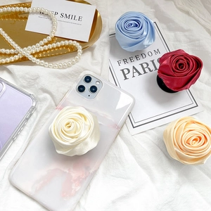 Macro detail of silky satin rose phone socket on a marble case with elegant props