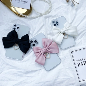 Detailed view of luxury phone cases featuring large satin bows and heart pearl charms