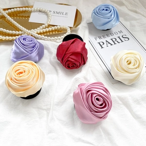 Macro detail of satin rose phone grips in six elegant colors on a white fabric background
