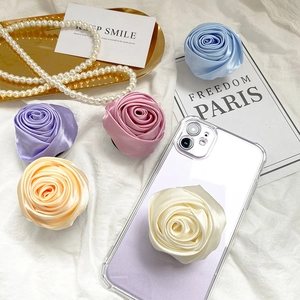 Detailed view of handmade satin rose phone grip sockets in multiple pastel colors
