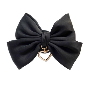 Foldable phone grip featuring black satin ribbon bow with pearl heart pendant