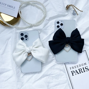 Chic iPhone 16 Pro Max case featuring a large satin bow and pearl heart pendant